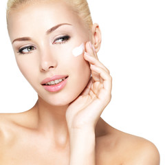 Obraz na płótnie Canvas Beauty face of woman applying cosmetic cream on face