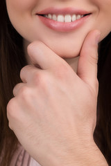 Thoughtful woman. Cropped image of male hand touching woman chin