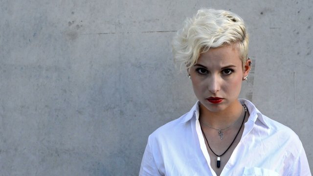 Woman with a fancy blond short hairstyle looking up in the camera