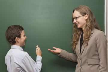 Teacher is showing to student something on the board