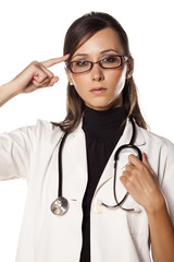 young woman doctor with a stethoscope touching her head