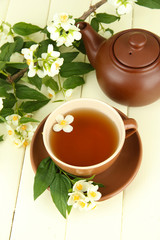 Cup of tea with jasmine, on wooden table, close-up