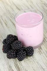Sweet blackberries with yogurt on table close-up