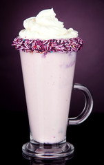Delicious milk shake on dark purple background