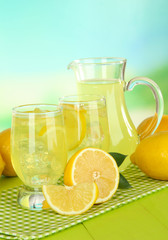 Naklejka na ściany i meble Delicious lemonade on table on light blue background