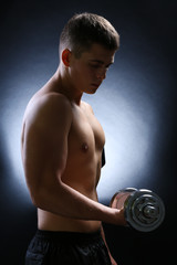 Fototapeta na wymiar Handsome young muscular sportsman execute exercise with