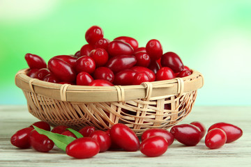 Fototapeta na wymiar Fresh cornel berries in basket on wooden table