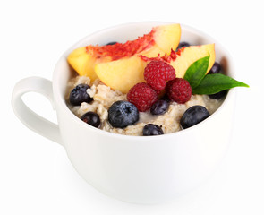Oatmeal in cup with berries isolated on white
