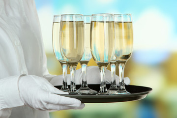 Waitresses holding tray with glasses of champagne
