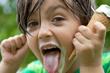 Young boy making a silly face with his ice cream © Andrew