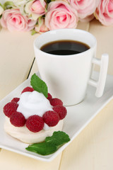 Tasty meringue cake with berries and cup of coffee,