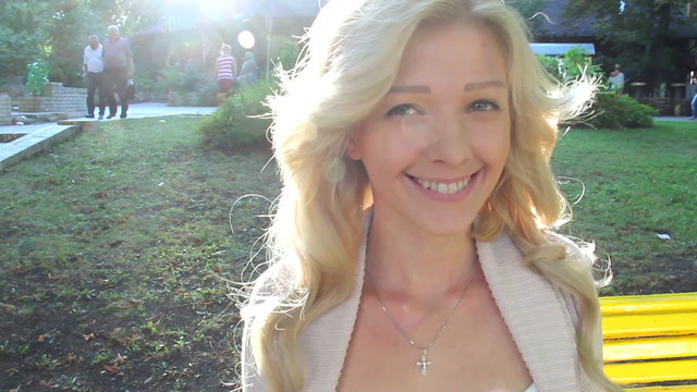Standing smiling blond girl in sunlight sun rays beautiful woman