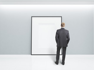 Fototapeta premium businessman looking at blank poster