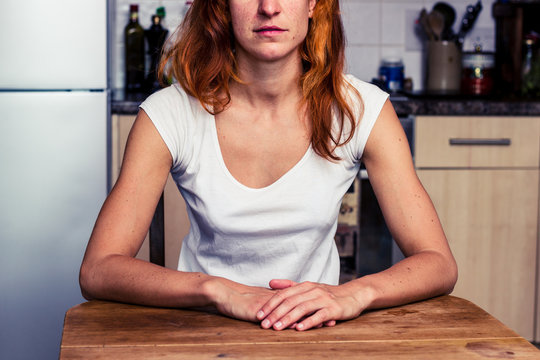 Calm woman sitting in her kitchen