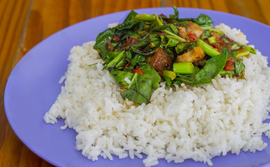 Kale with crispy pork rice on wood table