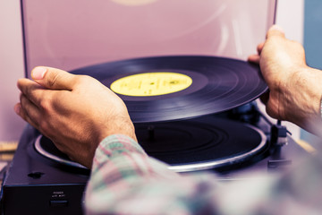 Hands placing record on turntable
