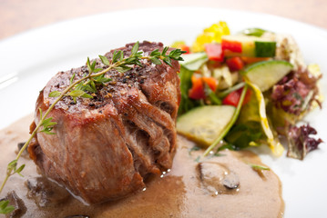Juicy steak with salad and mushroom sauce