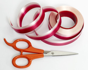 Curling red and white ribbon with scissor