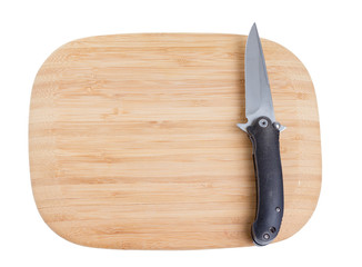 Bamboo cutting board with a knife.