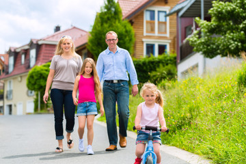 Family having walk in front of homes in village