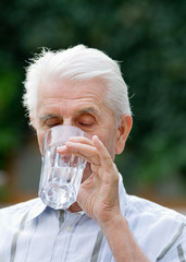 Older man drinking water from glass