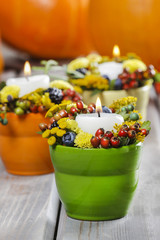 Candle holder decorated with autumn flowers and other plants