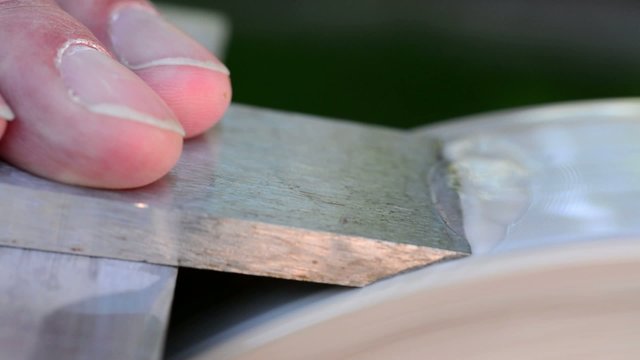 Sharpening a chisel on a stone wheel