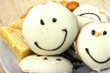 smiling cookies close-up on a plate with other cakes