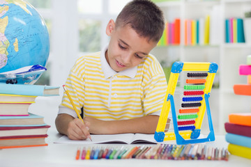 young boy sitting at his desk at home and learn