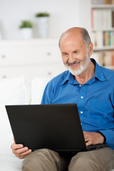 Fototapeta premium älterer mann mit laptop auf dem sofa
