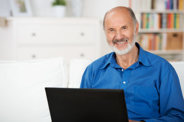 Fototapeta premium lächelnder senior mit laptop zu hause