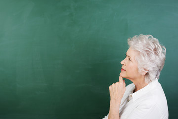 seniorin schaut nachdenklich an die tafel
