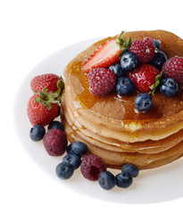 Pancakes with berries and honey over white