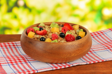 Oatmeal with fruits on table on bright background