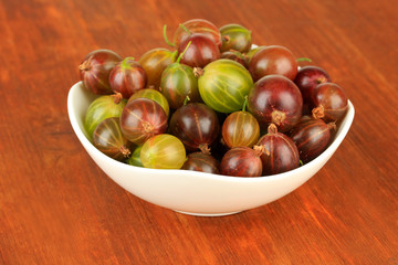 Obraz premium Fresh gooseberries in bowl on table close-up