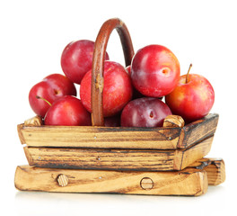 Ripe plums in basket isolated on white