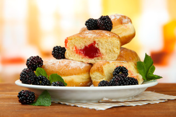 Tasty donuts with berries on wooden table