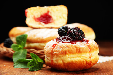 Tasty donuts with berries on wooden table