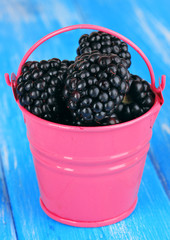 Sweet blackberries in bucket on table close-up