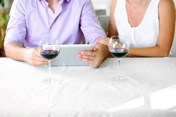 Young couple  taking photo with tablet in restaurant