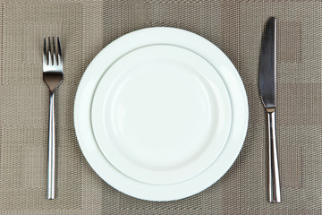 Knife, color plate and fork, on color background