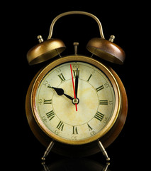 Old alarm clock isolated on black