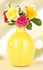 Beautiful bouquet of bright flowers in color vase,