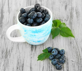 Blueberries in cup on wooden table