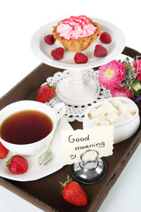 Cup of tea with cakes on wooden tray isolated on white