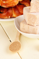 Dry yeast with pastry on wooden table close-up