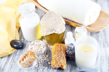 Honey and milk spa with oils and honey on wooden table close-up