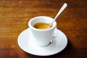 White espresso cup standing on the wooden table