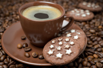 cup of coffee and Christmas cookies on the coffee beans