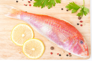 fresh surmullet, lemon and spices on a cutting board, top view